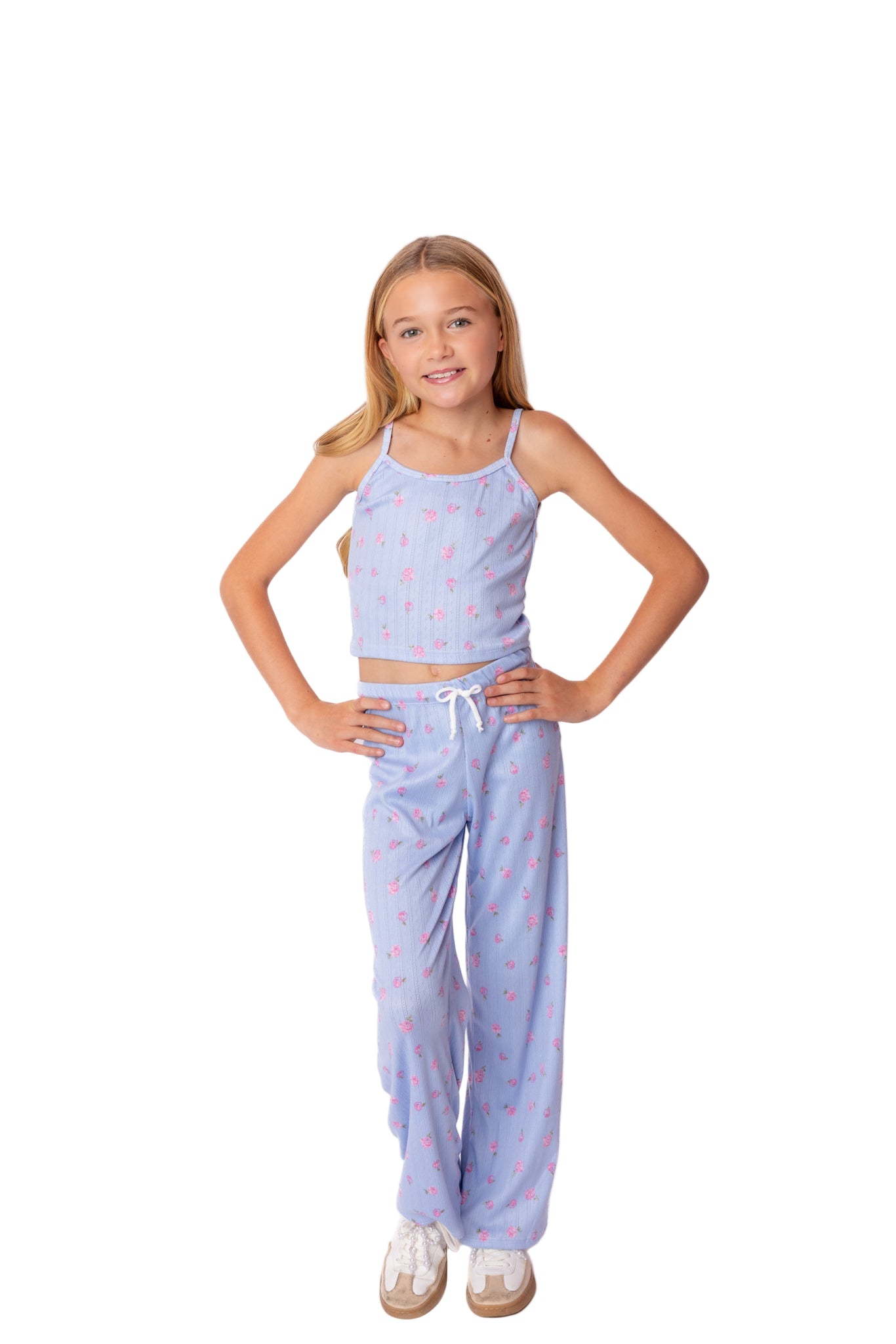 Young girl wearing a light blue pajama set with a white background
