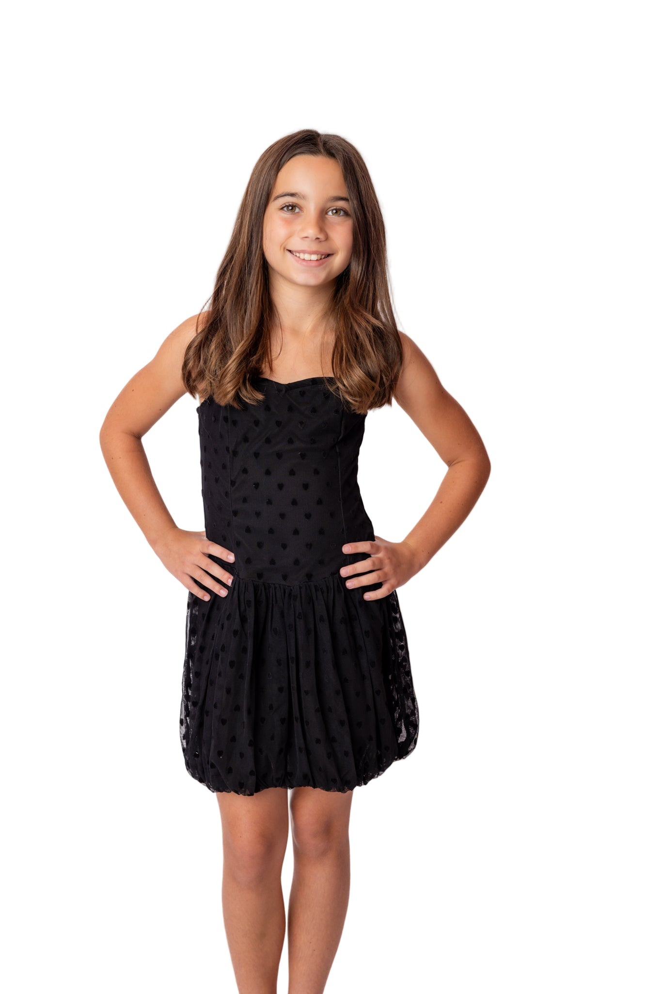 Young girl wearing a black polka dot dress on a white background