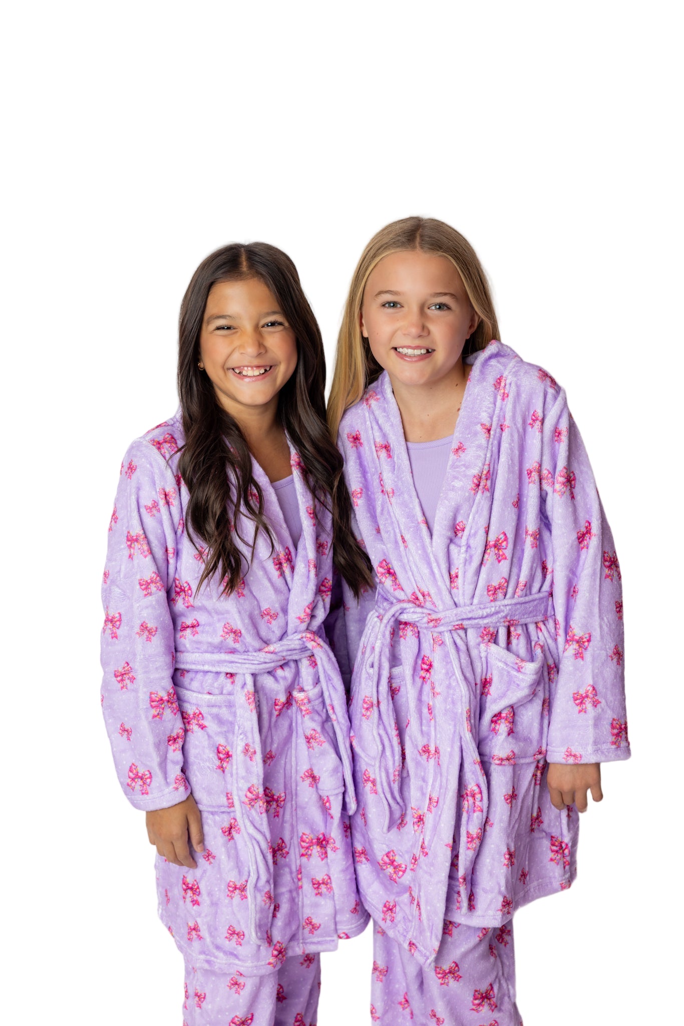 Two children wearing matching purple robes with pink butterfly patterns on a white background