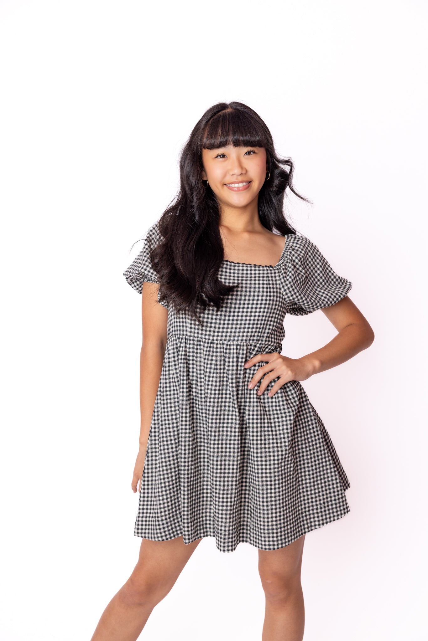 Woman wearing a black and white checkered dress on a white background