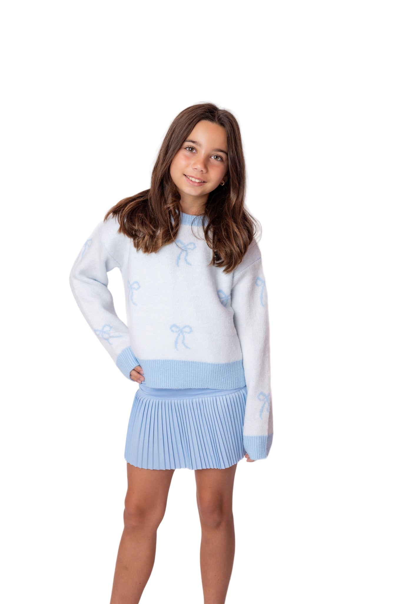 Young girl wearing a light blue sweater with bow details and a matching skirt with preppy style. Newport Beach Frankies on the Park type store in Orange County. Viral teen store newport beach.