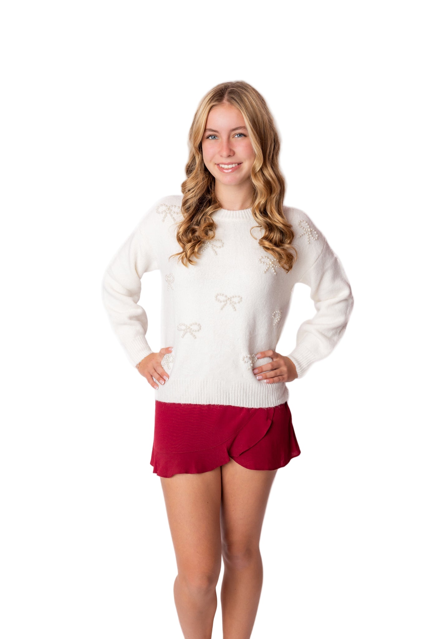 Woman wearing a white sweater with peal bows  patterns and red skirt on a white background from Leypop Shop. Local tween store. Viral teen fashion style. Viral ONline store for tweens
